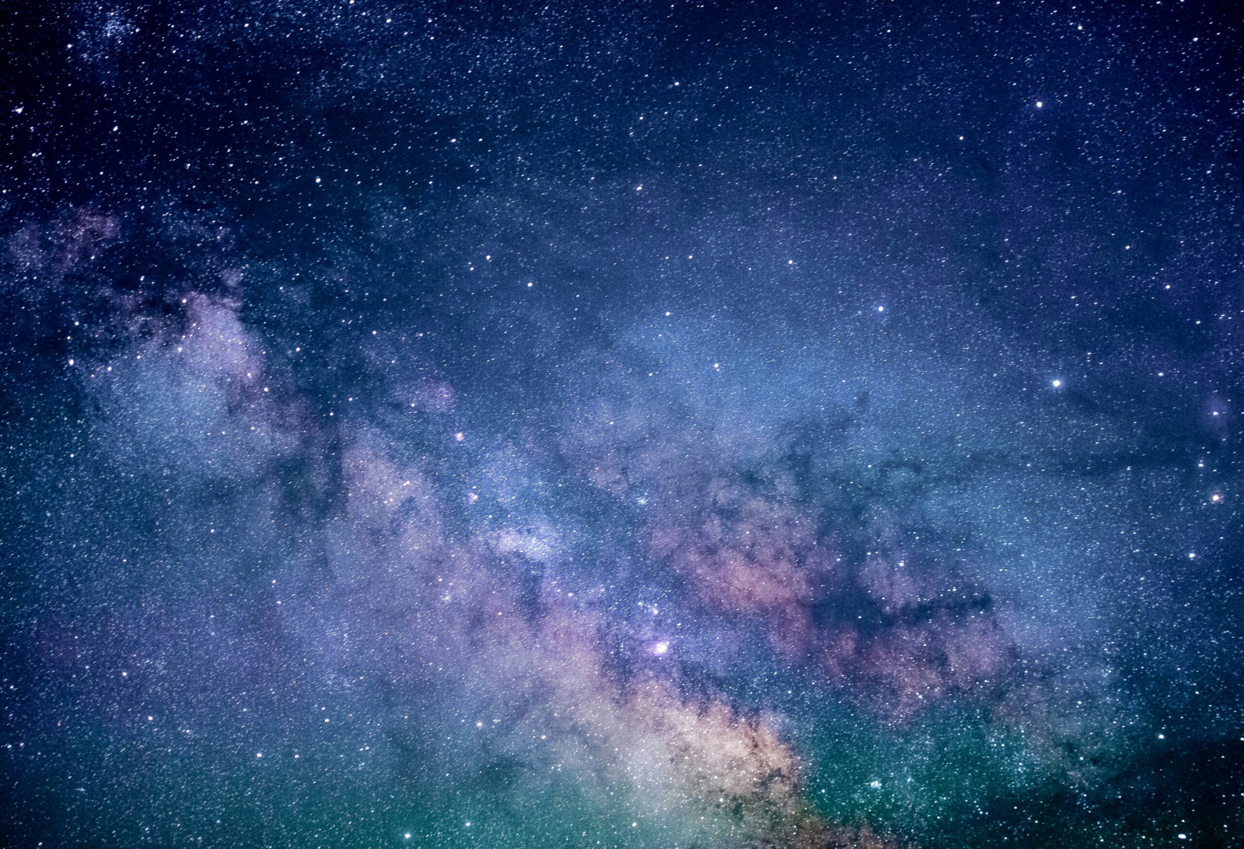 A colorful image of space, showing what seems to be nebulas and stars in various shades of purple and blue with some green and pink. The image gives a calming feeling.