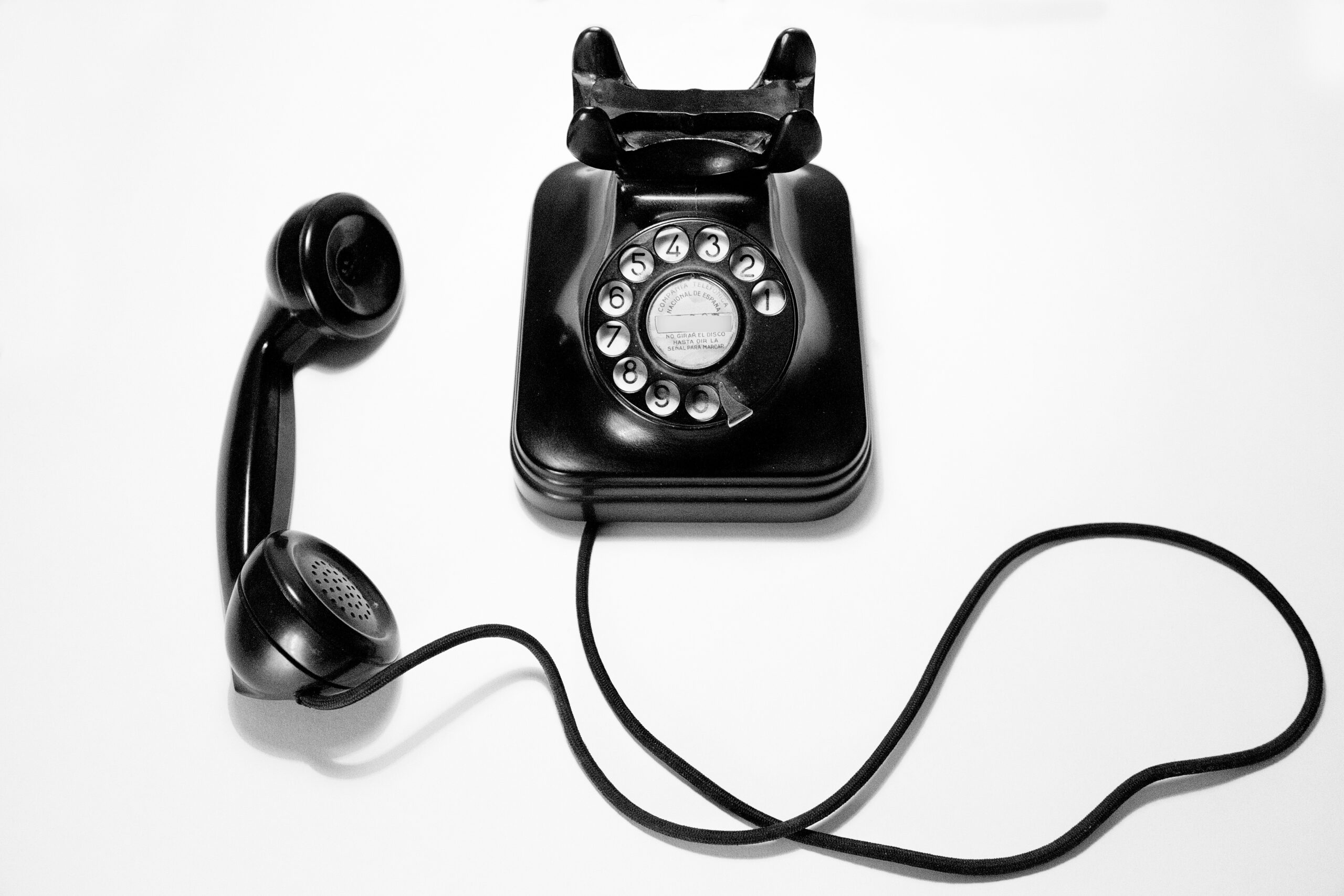 A rotary phone in black against a white background.
